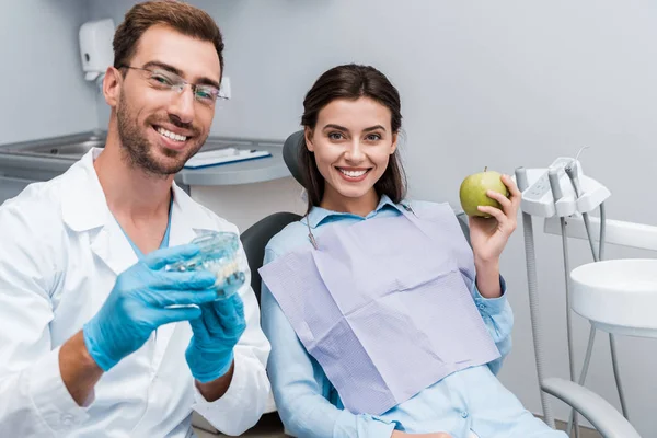 Enfoque Selectivo Dentista Alegre Gafas Que Sostienen Modelo Dientes Cerca — Foto de Stock