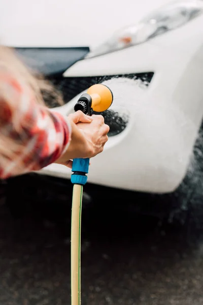 Wykadrowany Widok Kobiety Mycie Samochodu Trzymając Myjkę Ciśnieniowa — Zdjęcie stockowe
