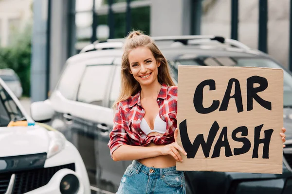 Szczęśliwa Dziewczyna Trzyma Karton Myjni Samochodowej Pobliżu Samochodów — Zdjęcie stockowe