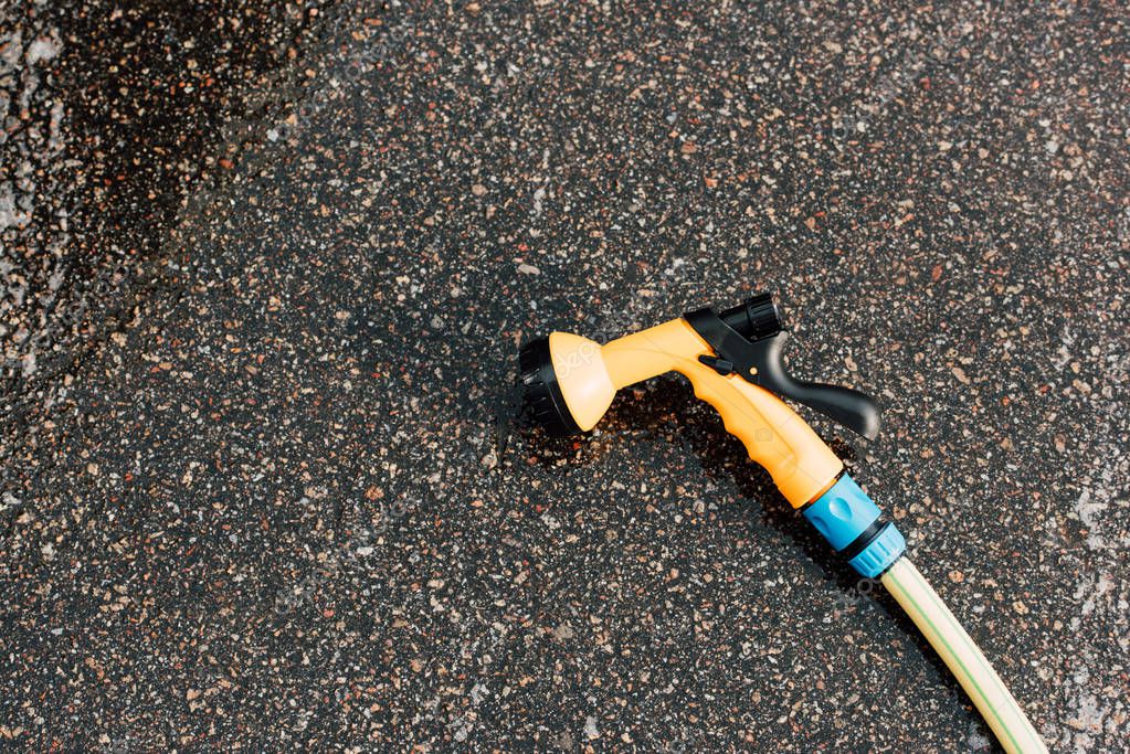 Modern pressure washer on grey and wet asphalt