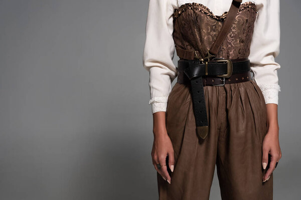 partial view of steampunk woman in white blouse on grey