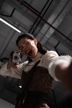 kızgın steampunk kadın çığlık seçici odak ve kamera tabanca ile amaçlayan