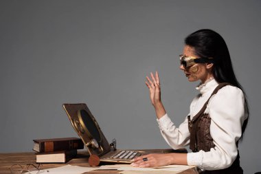 gri izole görüntülü sohbet sırasında el sallayarak gözlük steampunk kadın
