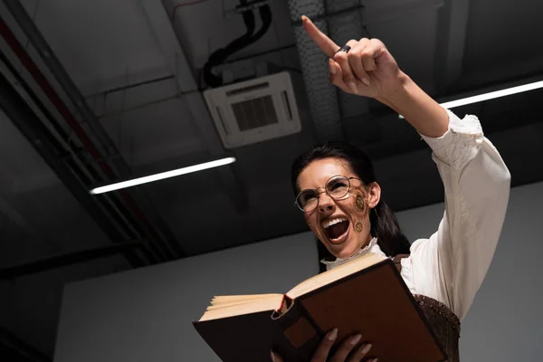 Bottom View Angry Steampunk Woman Holding Open Book Screaming Pointing — Stock Photo, Image