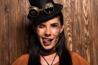 gülümseyen steampunk kadın ön görünümü yanıp sönen ve ahşap üzerinde dil dışarı yapışmasını