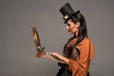 gri izole steampunk dizüstü bilgisayar kullanarak gözlük ile üst şapka kadın