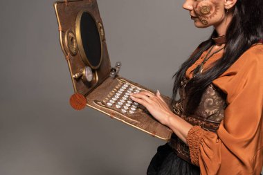 gri izole steampunk dizüstü bilgisayar kullanarak kadının kırpılmış görünümü