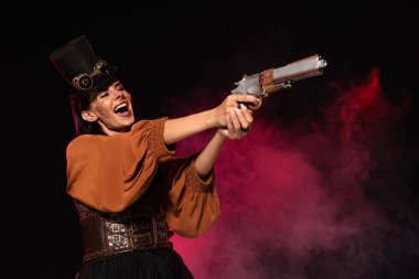 üst şapka güzel steampunk kadın tabanca tutan ve siyah pembe duman çığlık
