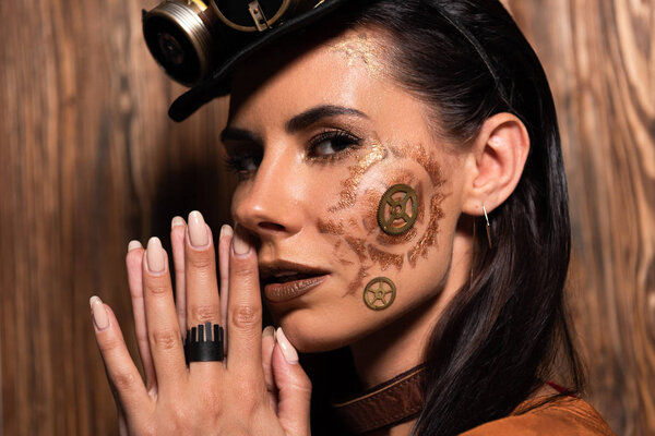 pensive steampunk woman showing please gesture on wooden