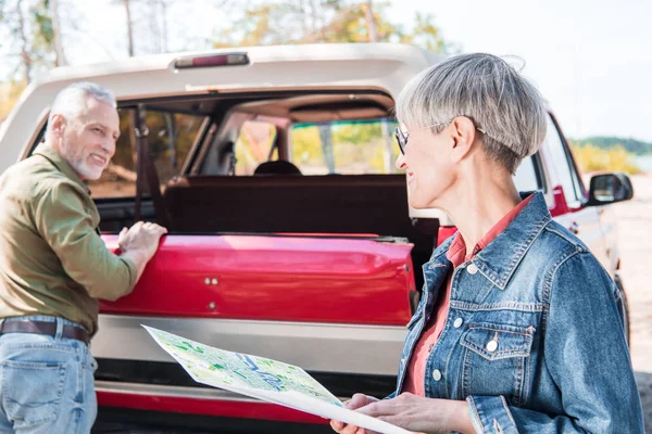 Senior Hombre Pie Cerca Coche Rojo Mientras Esposa Sosteniendo Mapa — Foto de Stock