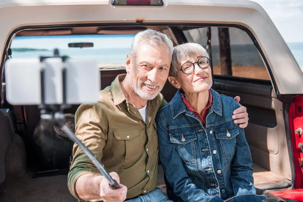 Sorrindo Casal Sênior Sentado Carro Abraçando Tomando Selfie — Fotografia de Stock