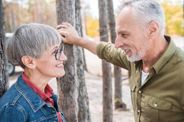 幸福的老年夫妇看着对方 在森林里微笑 — 图库照片