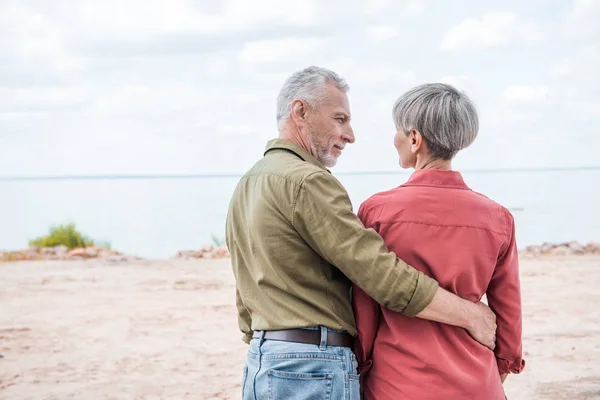 Vissza Véve Vezető Házaspár Felkarolása Mosolyogva Strandon — Stock Fotó