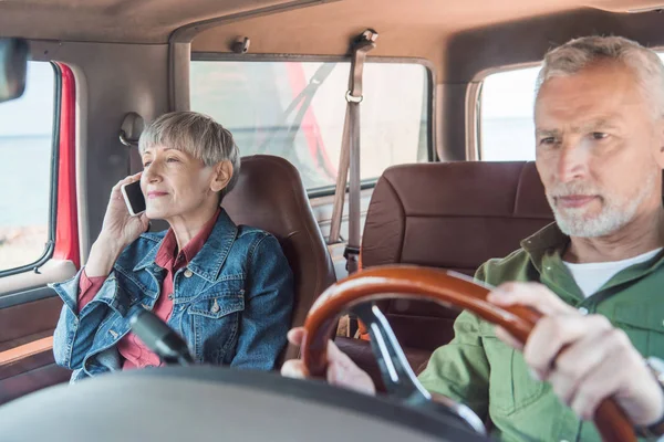 老年妇女说话的智能手机 而丈夫开车 — 图库照片