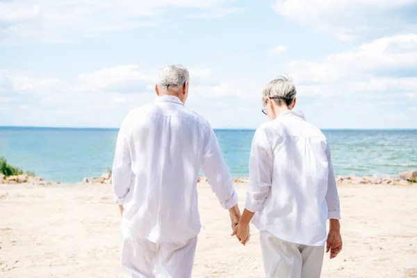 Back View Senior Couple White Shirts Holding Hands Beach — Stock Photo, Image