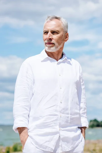 Pensive Senior Man White Shirt Standing Hands Pockets Blue Sky — Stock Photo, Image