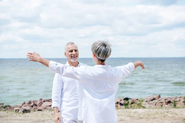 Vista Trasera Mujer Mayor Abrazando Marido Sonriente Playa — Foto de Stock