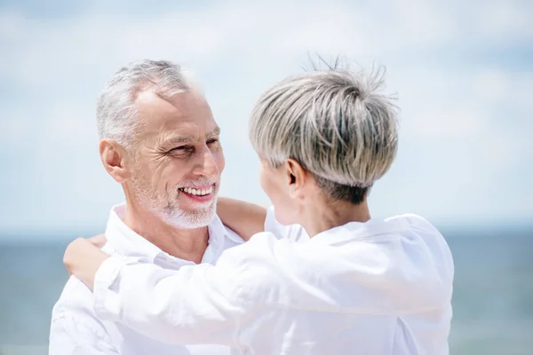 Szczęśliwy Starszy Para Biały Koszule Obejmując Patrząc Każdy Inny Pod — Zdjęcie stockowe