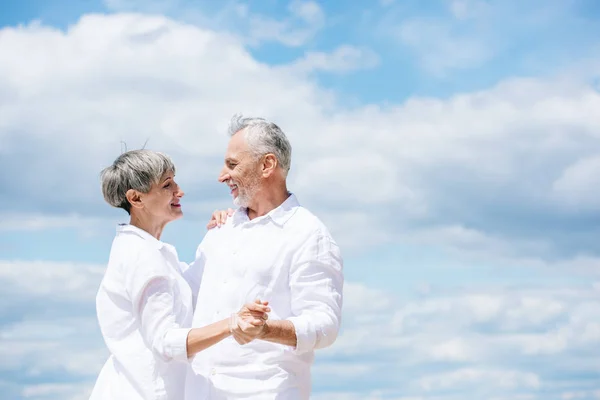 Feliz Casal Sênior Olhando Para Outro Enquanto Dança Sob Céu — Fotografia de Stock