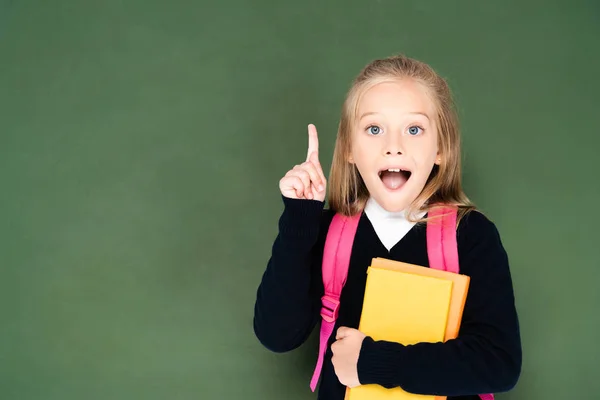 Excited Schoolgirl Holding Book Showing Idea Gesture While Standing Green — Stock Photo, Image