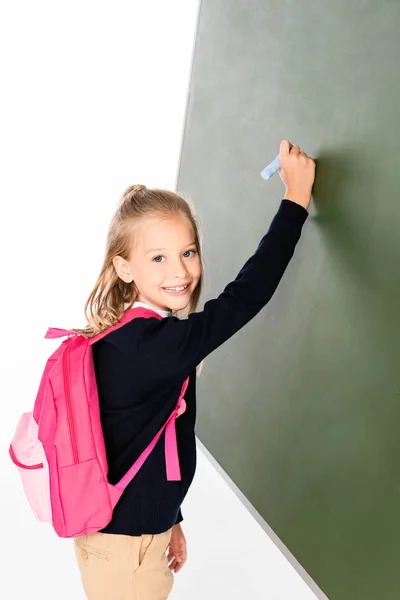 Cheerful Schoolgirl Writing Green Chalkboard While Smiling Camera — Stock Photo, Image