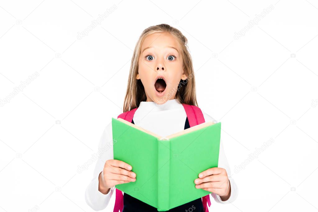 shocked schoolgirl holding book while looking at camera isolated on white