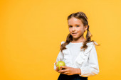 boldog gyermek gazdaság ízletes almát, és mosolyogva izolált narancs 