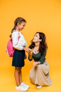 neşeli anne ve kızı portakal izole lezzetli elma tutarak 