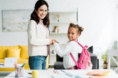mutlu anne ve neşeli ve sevimli kızı evde el ele tutuşarak 
