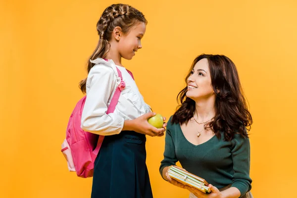 Happy Mother Holding Books Daughter Apple Isolated Orange — Stock Photo, Image
