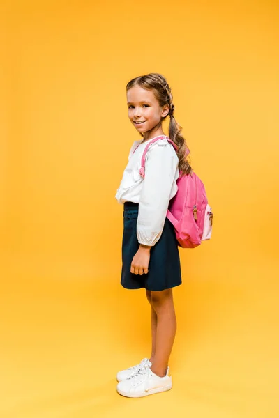 Turuncu Üzerinde Dururken Kameraya Bakan Mutlu Okul Çocuğu — Stok fotoğraf