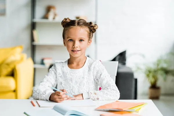 Niño Feliz Sosteniendo Lápiz Color Mientras Está Sentado Cerca Mesa — Foto de Stock