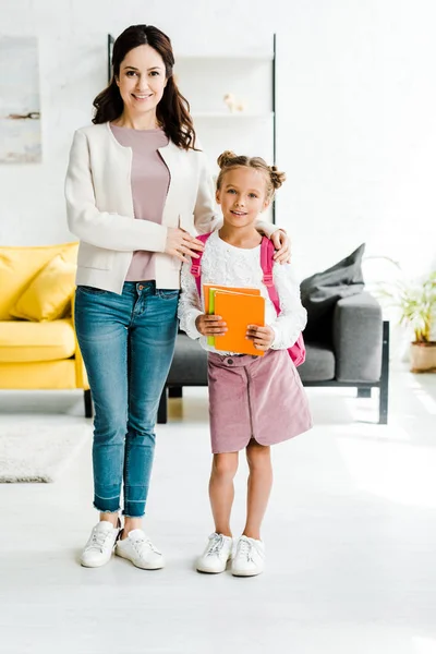 Gelukkige Moeder Staat Met Vrolijke Dochter Boeken — Stockfoto