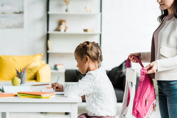 Recortado Vista Madre Sosteniendo Rosa Mochila Cerca Hija Dibujo Casa — Foto de Stock