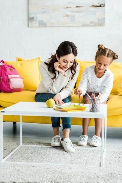 Feliz Madre Mirando Hija Dibujo Mientras Sentado Sofá — Foto de Stock