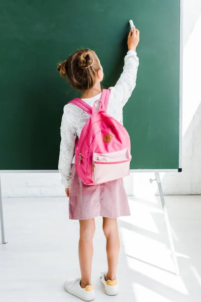 Back View Schoolgirl Standing Backpack Holding Chalk Green Chalkboard — Stock Photo, Image