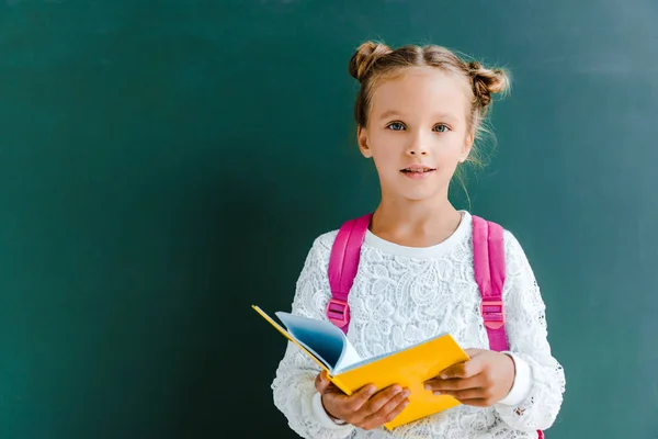 Niño Feliz Sonriendo Mientras Está Pie Con Libro Sobre Verde — Foto de Stock