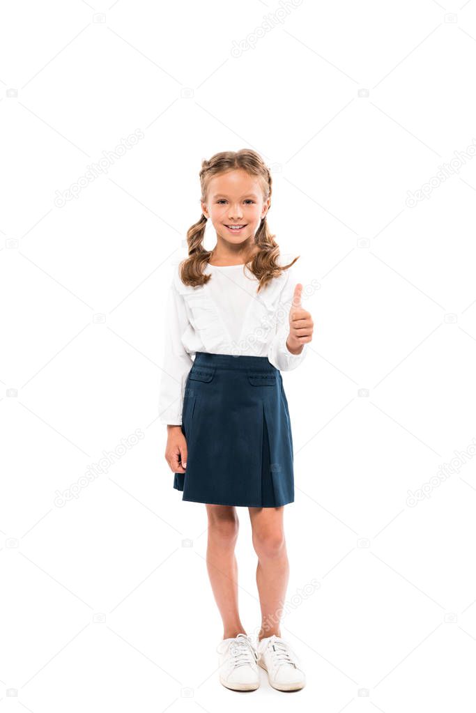 Happy schoolkid showing thumb up an d standing isolated on white