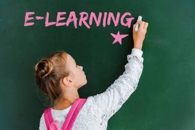 yeşil e-öğrenme yazısı ile tebeşir tahtası yakınında tebeşir tutan schoolchild 
