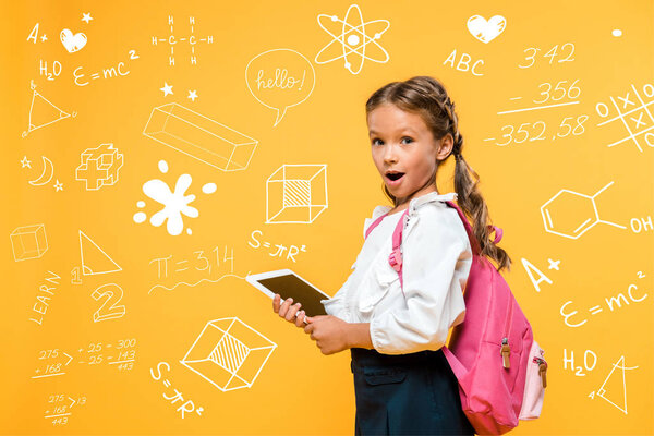 surprised schoolkid holding digital tablet with blank screen near mathematical formulas on orange 