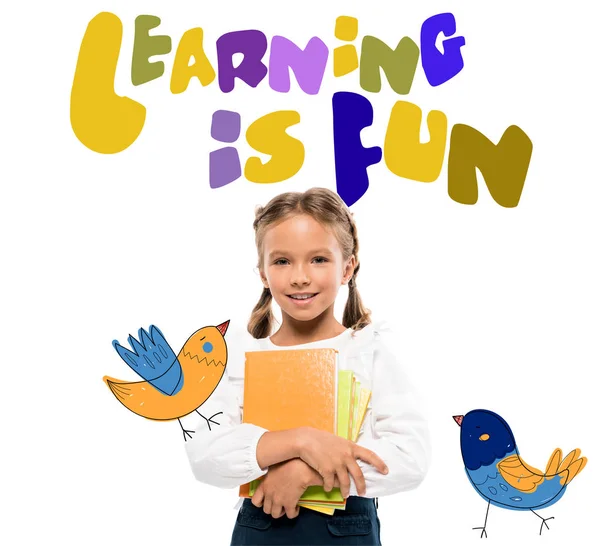 happy schoolkid holding books near learning is fun lettering on white