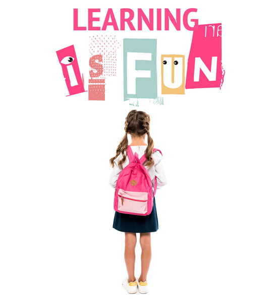back view of schoolchild standing with pink backpack near learning is fun lettering on white 