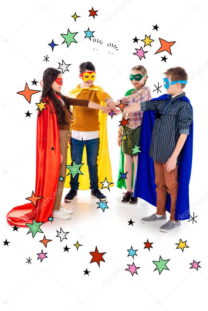 happy kids in superhero costumes and masks stacking hands near stars on white 