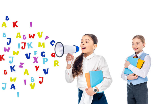 школьницы в формальной одежде держат книги и кричат в мегафоне возле букв на белом
 