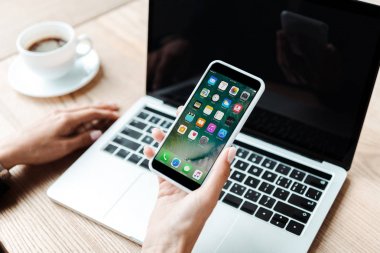 Kiev, Ukrayna - 5 Ağustos 2019: ofiste iphone tutan kadının kırpılmış görünümü 