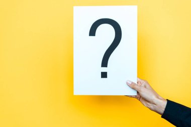 cropped view of woman holding board with question mark on orange  clipart