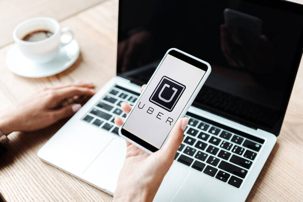 KYIV, UKRAINE - AUGUST 5, 2019: cropped view of woman holding smartphone with uber app 