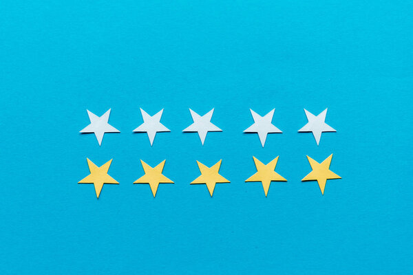 top view of white and yellow stars isolated on blue 