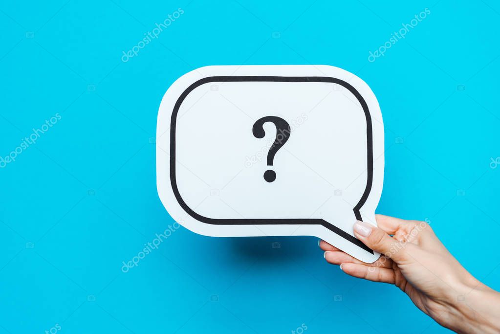 cropped view of woman holding white speech bubble with question mark on blue