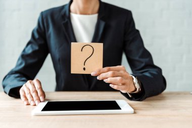 dijital tablet yakınında soru işareti ile yapışkan not tutan kadın kırpılmış görünümü 